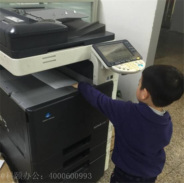 我们家小小帅掂着小脚在操作着柯尼卡美能达复印机的样子-科颐办公