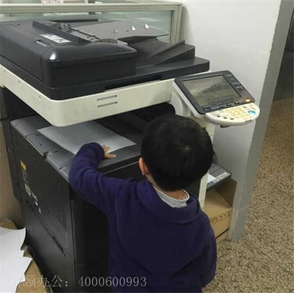 我们家小小帅在操作着柯尼卡美能达复印机的样子-科颐办公